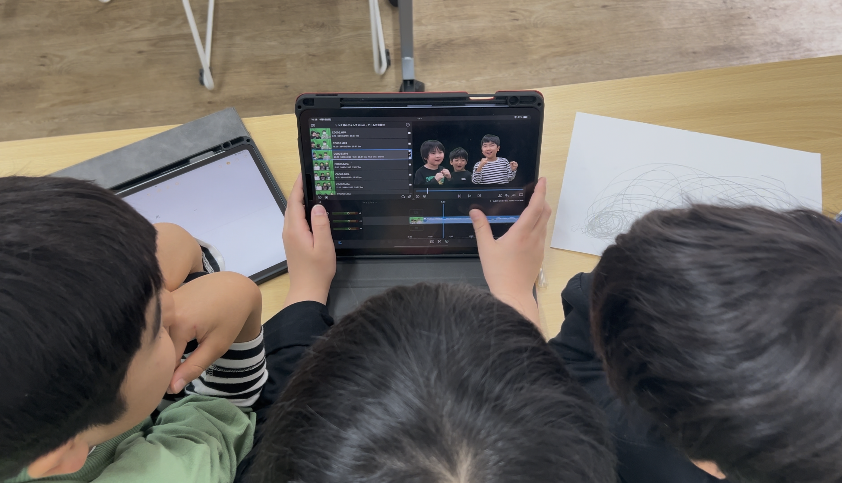 タブレットを囲んで映像を編集する子どもたち